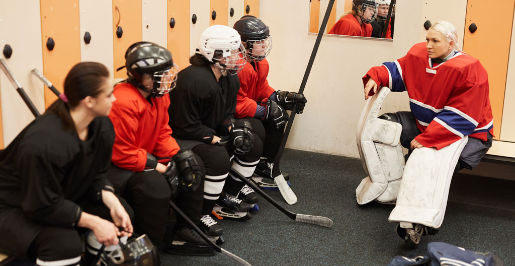 Joueurs en discussion dans vestiaire avec tasses de thé visibles
